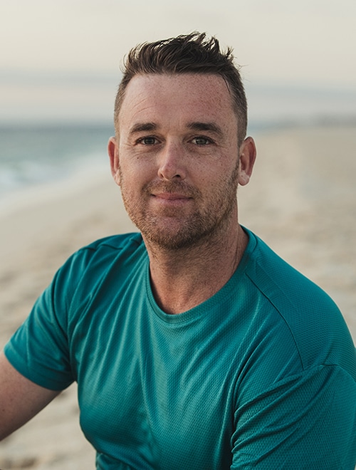 Man sitting on a beach thinking mindfully